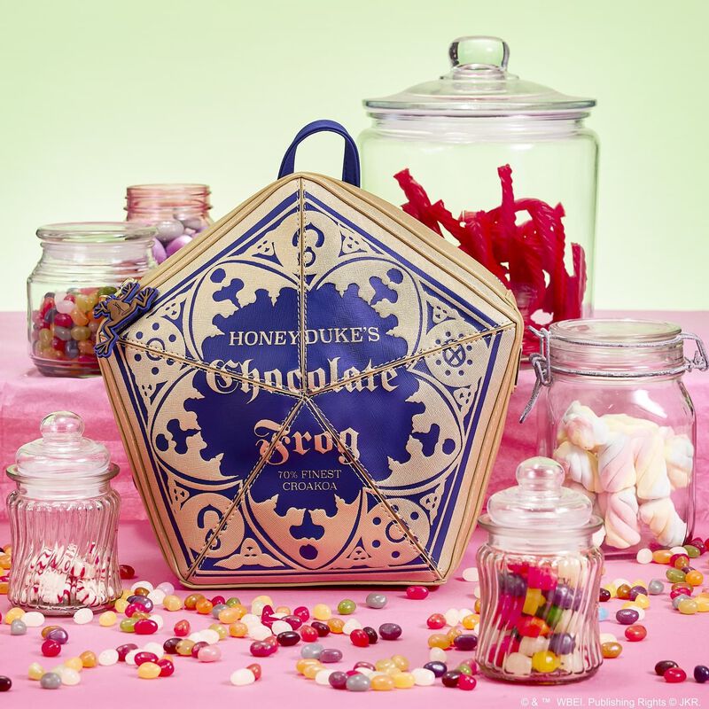 Image of our Chocolate Frog backpack sitting against a pink background surrounded by candy
